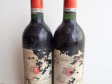 two bottles of wine sitting on top of a table next to each other