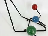 three different colored balls hanging from a black metal rack