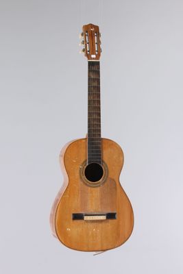 une guitare suspendue à une corde au mur