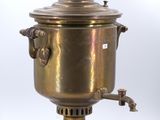une bouilloire ancienne en laiton posée sur un support, sur fond blanc