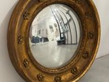 un miroir accroché au mur, à côté d'un mur