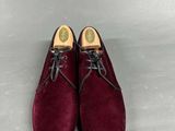 a pair of burgundy sued shoes with laces on them