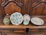 trois assiettes et un vase posés sur une étagère en bois