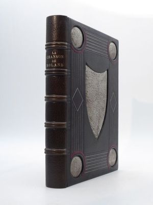 un vieux livre posé sur une surface blanche ornée d'un blason