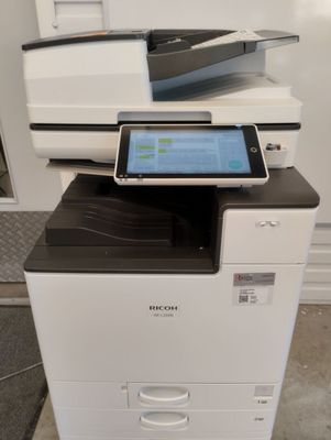 une imprimante blanche sur laquelle est posée une tablette