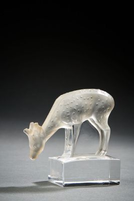 a white sculpture of a deer on a clear base