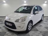 la petite voiture blanche est garée sur un carrelage à carreaux