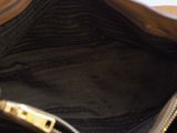 a hand holding a purse that is sitting on a table