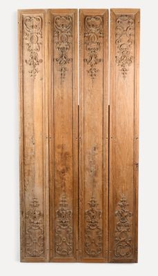 une paire de portes anciennes en bois sculpté ornées de motifs floraux