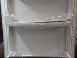 an image of a white refrigerator in the middle of a room