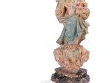 une image représentant une statue d'une femme tenant un enfant sur un rocher