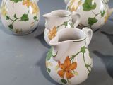 four small vases sitting on a table next to each other