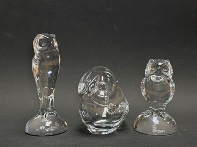 trois figurines en verre posées sur une table