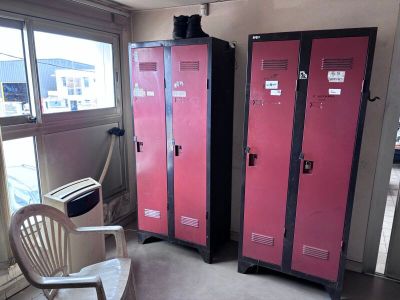 deux casiers rouges dans une pièce où se trouve une chaise blanche