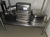 several pans and pans are stacked on a metal shelf in a kitchen
