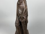 a bronze statue of a woman holding a basket of flowers