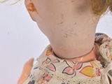 a doll with a red hair and a flowered dress