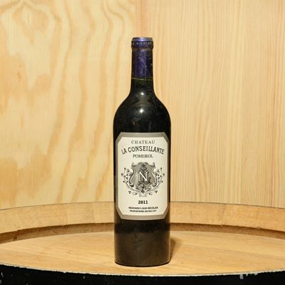 a bottle of wine sitting on top of a barrel