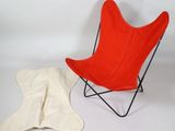 a red chair and a white blanket on a white background
