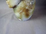 a vase that has a bird on top of it