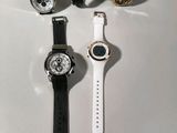 four different watches sitting on top of a table next to each other