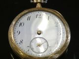 gros plan d'une montre de poche sur une surface noire