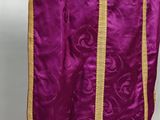 a close up of a purple and gold stoler on a mannequin stand