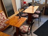 tables and chairs in a restaurant with a chalk board on the wall