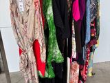 a lot of clothes hanging on a rack in a room