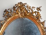 a mirror that has a gold frame with angels on it