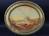 une image représentant une peinture sur une plaque en or, avec en arrière-plan une peinture représentant une ville