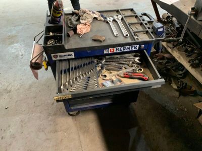 un homme debout à côté d'une table sur laquelle se trouvent des outils