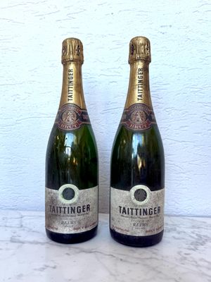 deux bouteilles de champagne posées l'une à côté de l'autre sur une table