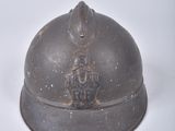 a small metal helmet on a white surface