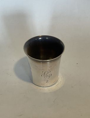 a silver cup sitting on a table with a white background