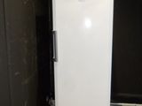 a white refrigerator in a room with a black wall