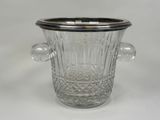 a glass vase with a silver lid on a white table