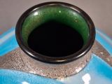 a blue and green vase sitting on a table