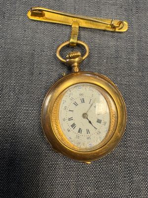 une image représentant une montre de poche en or ornée de chiffres romains
