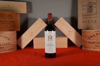 une bouteille de vin posée sur une table à côté de caisses en bois