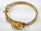 an image of a close up of a gold bracelet with a lizard on it