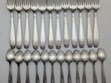 many forks and spoons arranged in a row