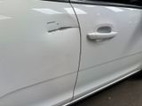 the door of a white car with a black handle and a white door handle