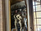 a statue in front of a mirror in a room
