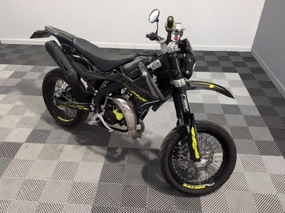a picture of a black and yellow motorcycle parked on a checkered floor