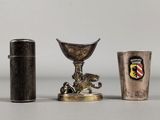 deux tasses en argent et un briquet sont posés sur une table