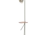 le lampadaire repose sur un pied, avec une table en bois en dessous