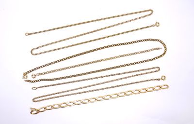 several gold chains on a white surface with a white background