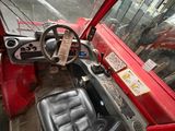 a red bus with a steering wheel and a black seat
