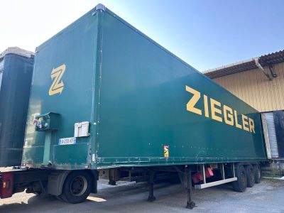 un camion vert garé devant un immeuble